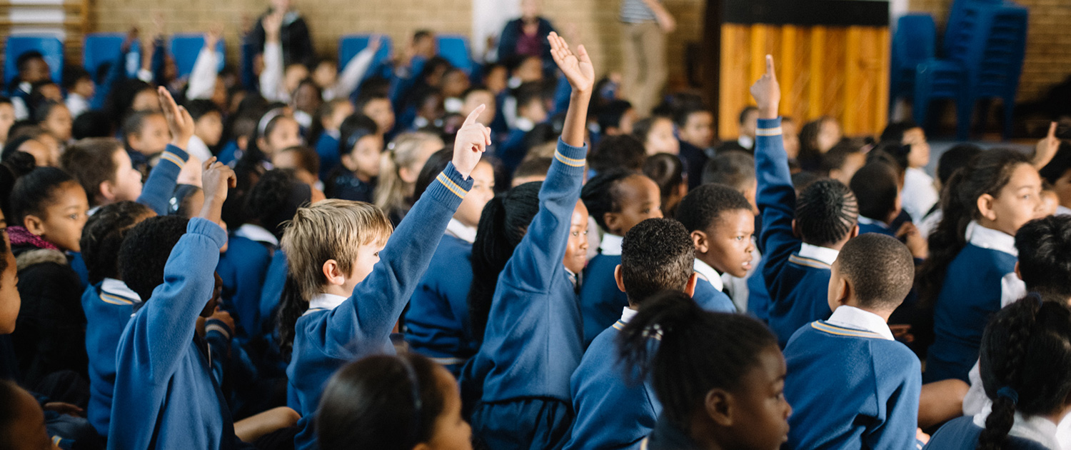 Learners raise their hands at Blind Buddy Day
